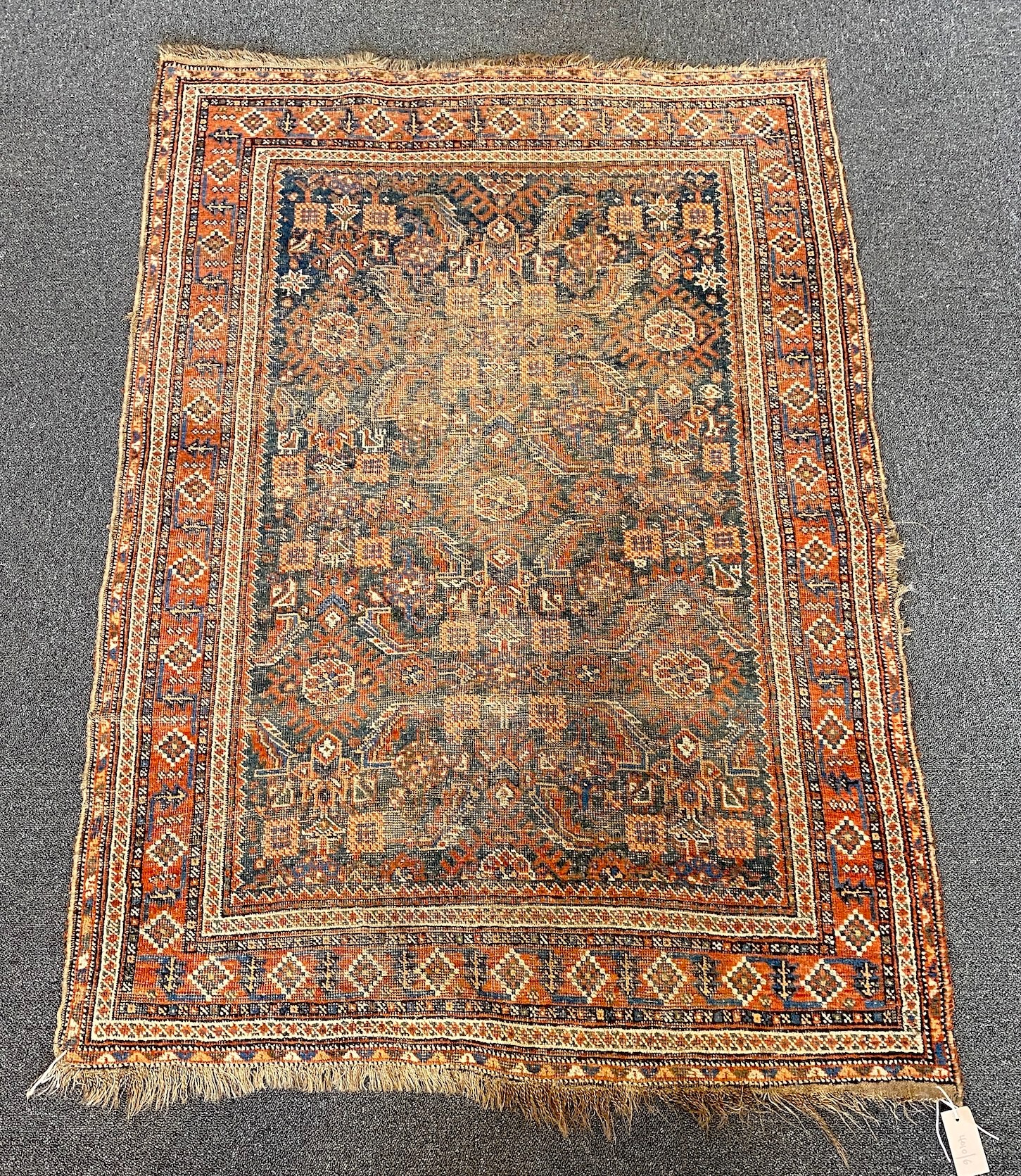 A Shiraz blue ground rug with dense floral field (worn), 144 x 102 cms